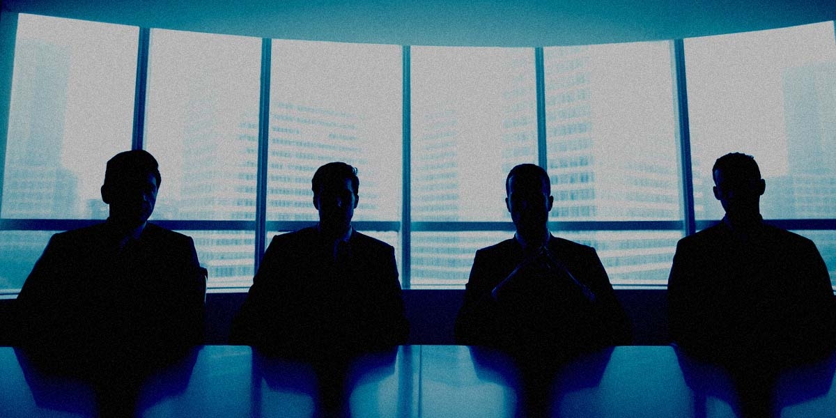 Board members in shadow sitting at a table